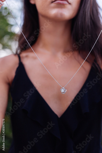 Outdoor portrait of woman in black dress with silver celtic knot necklace 