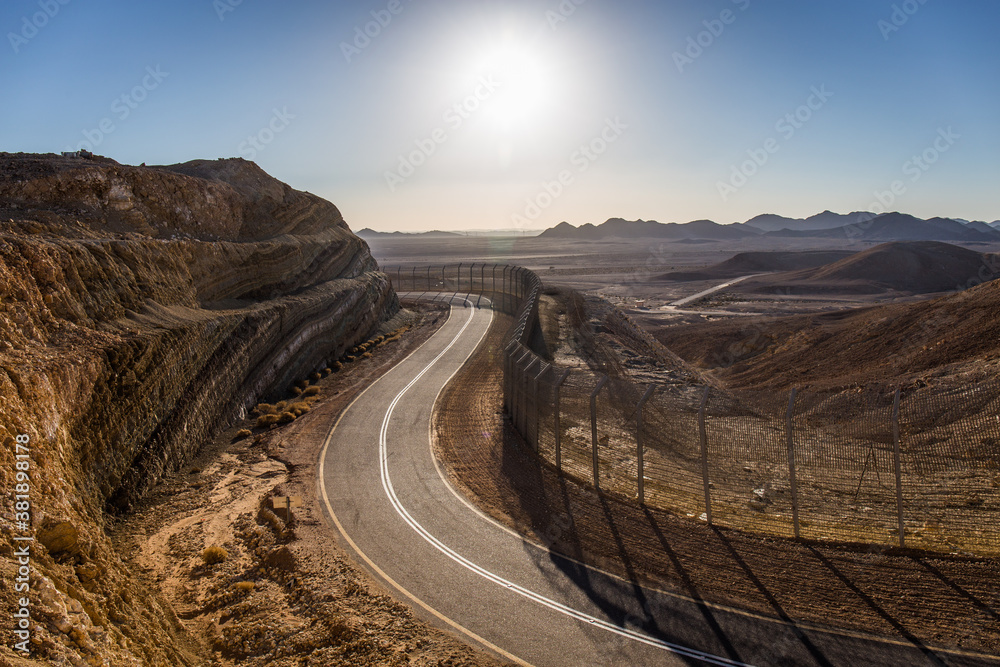 Egypt Israeli border with two layers of razor wire fence in mountains sunset