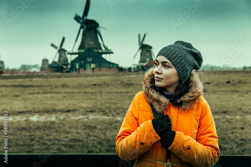 Young tourist woman and windmills of Zaanse Schans on background