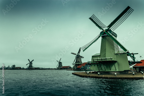 view on old windmills of Zaanse Schans from the river at winter time