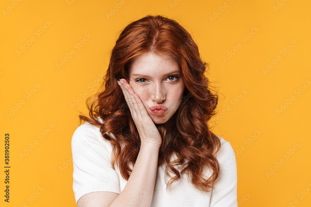 Image of ginger unhappy girl with toothache posing on camera Image of ginger unhappy girl with toothache posing on camera