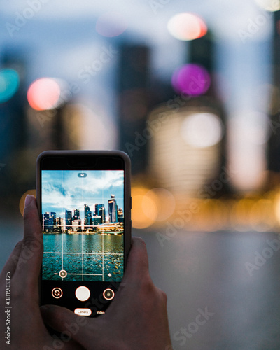 a person taking a photo of a cityscape using a phone