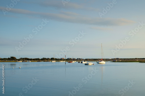 West Wittering, Chichester Harbour, South of England. Boats, the evening sky and a calm sea create a tranquil scene.
