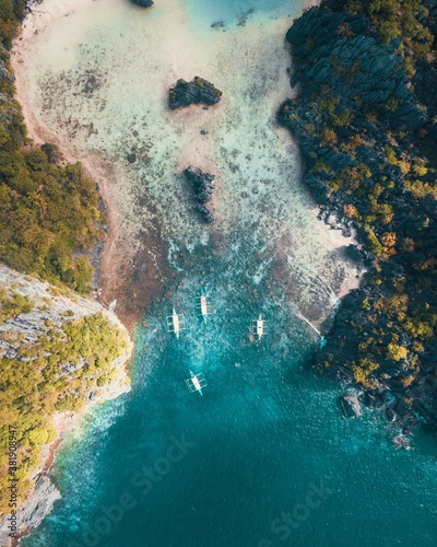 a top-down shot of boats leaving an island