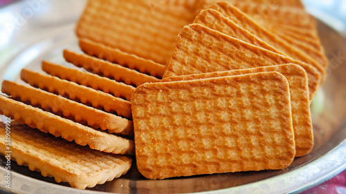 Wheat biscuits in the steel plate with blury background. Indian biscuits popularly known as Chai-biscuit in India photo