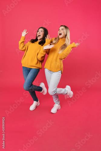 Image of excited caucasian women looking aside with throwing up hands