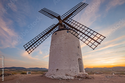 Beautiful white spanish windmill on the hill at fairy sunset near the castle in Consuegra, Toledo province, Spain