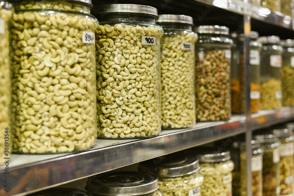 Cashew nuts in glass bottles. Raw and processed nuts Kerala, India. Whole, salted Anacardium occidentale seeds isolated food photo, close up. Cashew nuts in glass bottles. Raw and processed nuts Kerala, India. Whole, salted Anacardium occidentale seeds isolated food photo, close up.