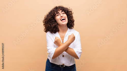 Tableau sur toile smiling cheerfully and celebrating, with fists clenched and arms crossed, feeli