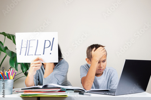 Learning difficulties, remote education, online learning and working at home. Tired mother and sad kid need help to do homework photo