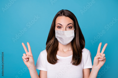 Photo of amazed excited girl enjoy covid quarantine weekend holiday make v-sign wear casual style clothes medical mask isolated over blue color background