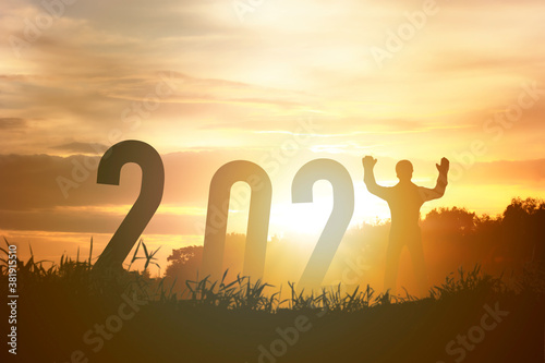 Happy new year 2021 silhouette concept Human standing with number with beautiful orange sky for change to new year 2021.