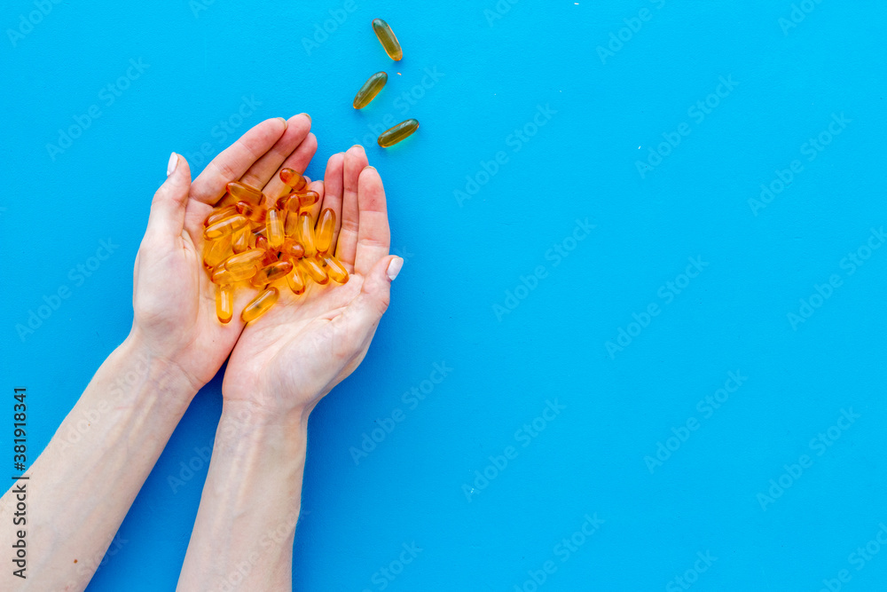 Omega fish cod liver oil capsules in hands, copy space Omega fish cod liver oil capsules in hands, copy space
