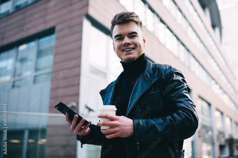 Cheerful man using smartphone on street Cheerful man using smartphone on street