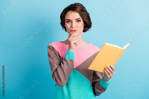 Photo portrait of curious thoughtful girl thinking about idea keeping book touching face isolated on bright blue color background