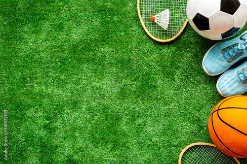 Sport games equipment on football field - balls  sneakers  rackets. Top view