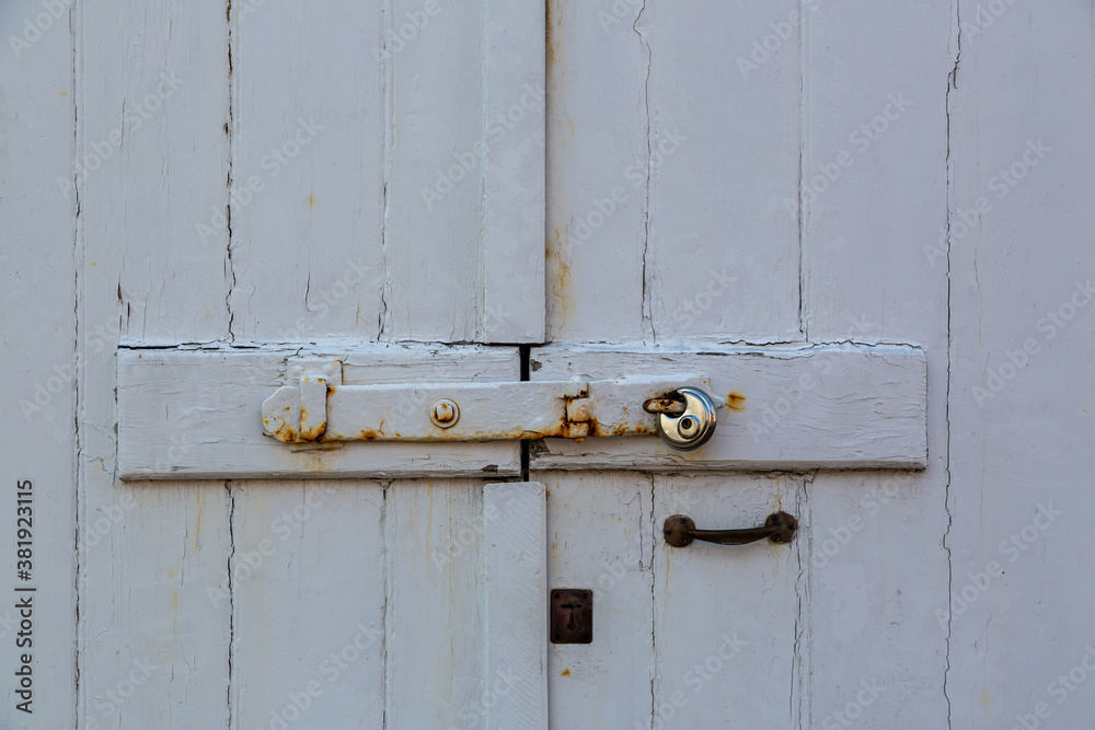 Wooden stable doors locked by a rusty bolts and a modern padlock Wooden stable doors locked by a rusty bolts and a modern padlock