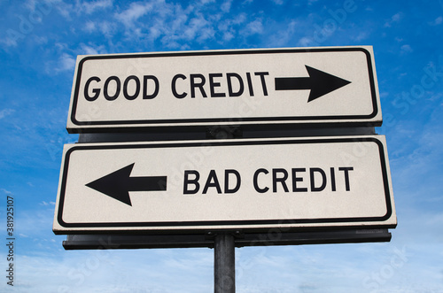 Good credit vs bad credit. White two street signs with arrow on metal pole with word. Directional road. Crossroads Road Sign, Two Arrow. Blue sky background. Two way road sign with text.