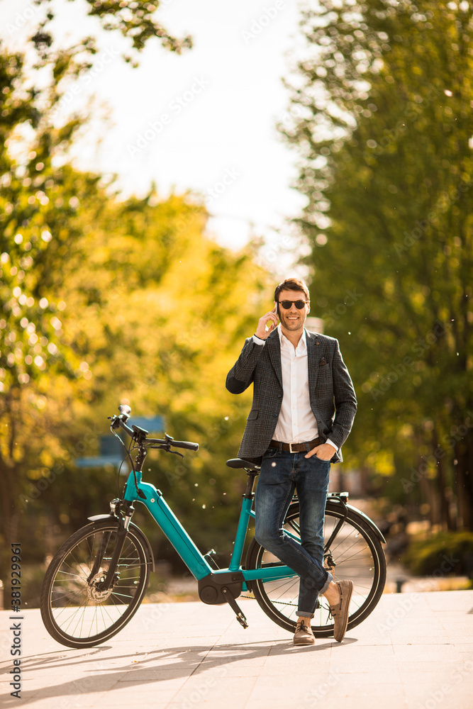 Young businessman on the ebike using mobile phone Young businessman on the ebike using mobile phone