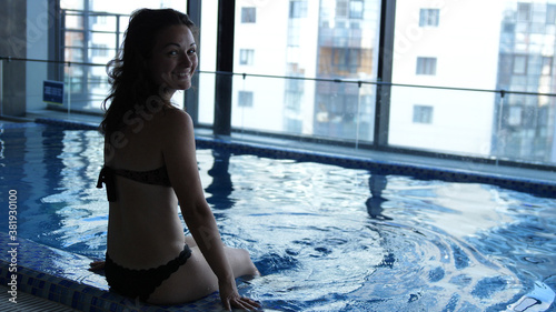 Close up of young woman is enjoying and having relax in swimming pool in a luxury wellness center.