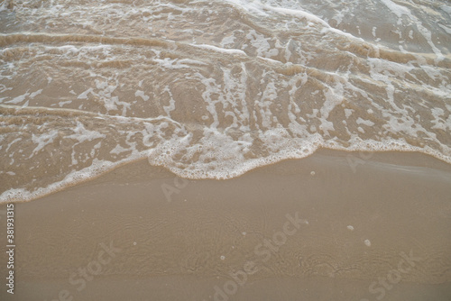 Nature background of seashore beach wave and coastline sand with sunlight water surface for holiday relaxation lifestyle concept