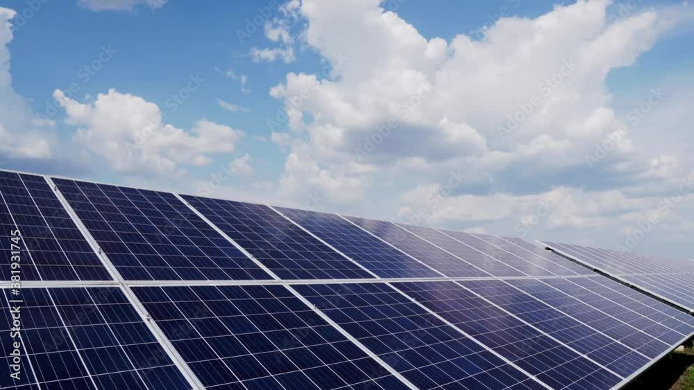 Large solar panels stand outdoors in a field, modern power plant, innovative equipment. Slide camera shot of the panels. Large solar panels stand outdoors in a field, modern power plant, innovative equipment. Slide camera shot of the panels.