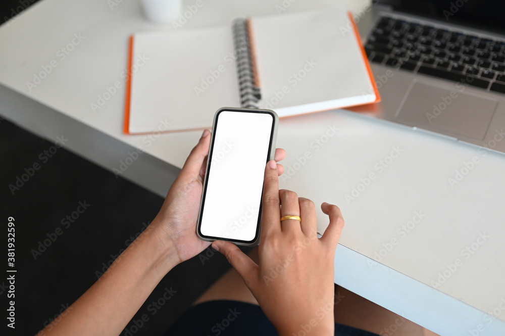 Top view businesswoman hands holding and using smartphone in modern office. Top view businesswoman hands holding and using smartphone in modern office.