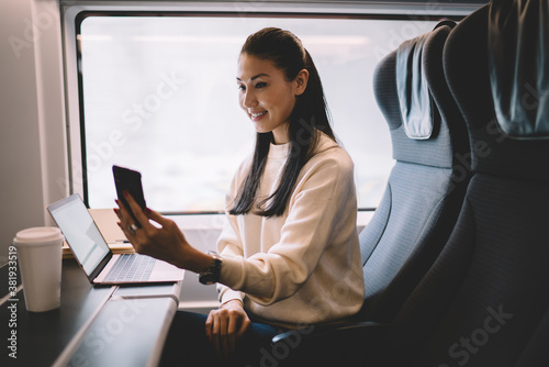 Focused young ethnic female sitting in train © BullRun