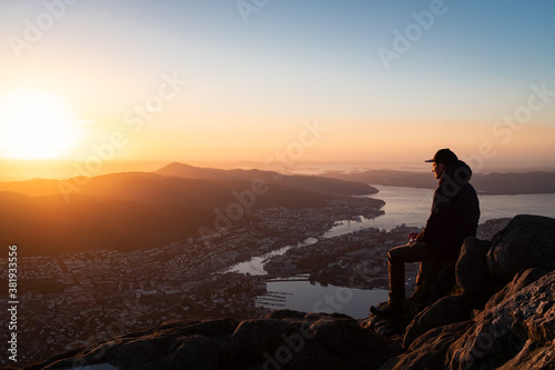 Man Looking Over Cityscape with Mountains and Fjord