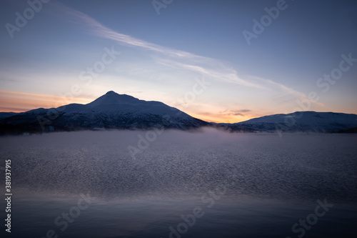 Mist Above Wintry Bay Water and Mountains at Sunset