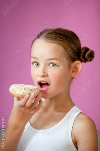 cute girl holding an appetizing glazed donut in her hands