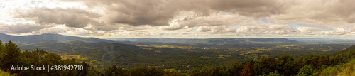 Panoramic view if Shenandoah valley observed from a scenic overlook by skyline drive. image features vast forests covering hills and mountains of blue ridge mountain range.