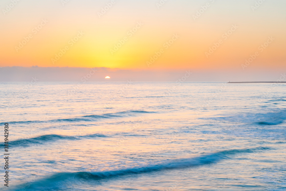 Obraz premium Sunset over ocean waves