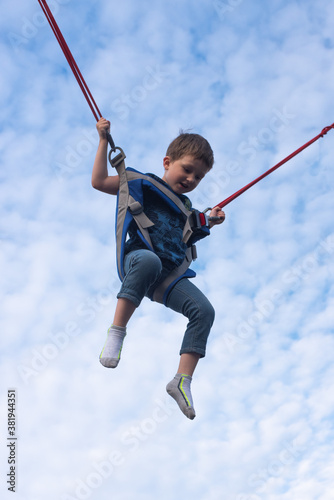 boy bungee jumping high into the sky