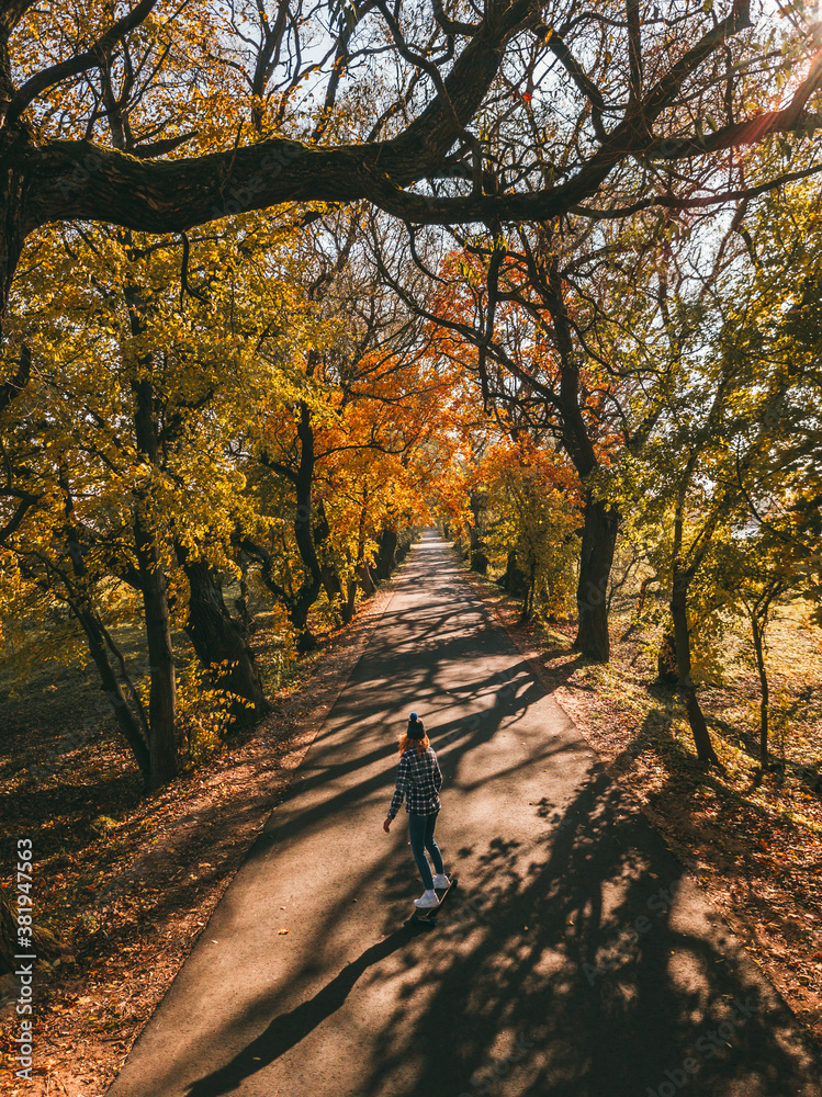 Girl rides a longboard on a highway outside the city. The spirit freedom and autumn adventures. Girl rides a longboard on a highway outside the city. The spirit freedom and autumn adventures.