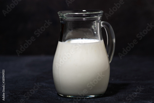 jug with fresh milk on a black background, closeup