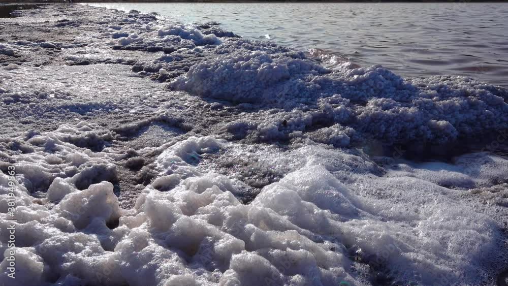 Kuyalnik estuary, Black Sea. White foam and crystals of table salt cover stones on the shore of a salt lake Kuyalnik estuary, Black Sea. White foam and crystals of table salt cover stones on the shore of a salt lake
