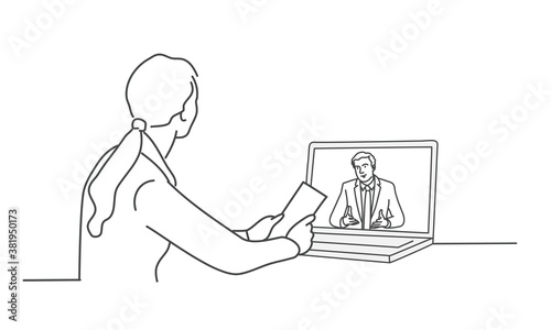 Girl sitting at a table in front of a laptop.
