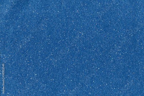 Glitter abstract background. Grain texture. White sparkles on blue fiber surface.