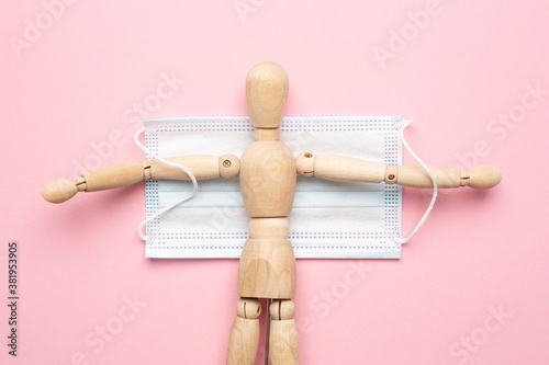 Tableau sur toile Wooden man with medical mask, second wave, protection from the covid virus