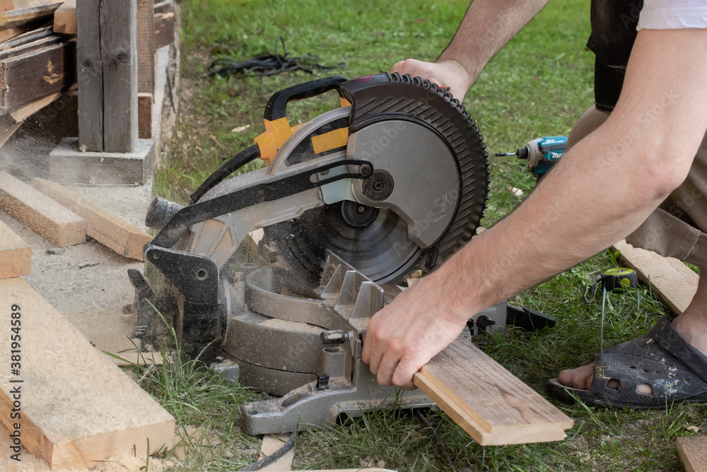 a worker saws a long wooden plank a worker saws a long wooden plank