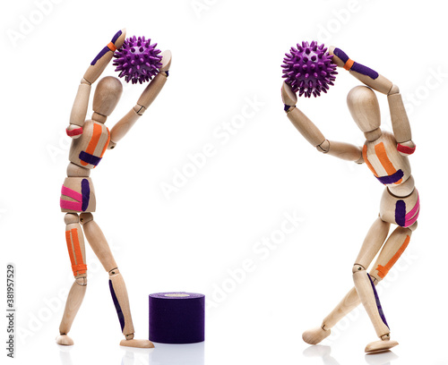 Kinesiology taping. Kinesiology tape on a.wooden mannequins. Traumatic rehabilitation, sport physical therapy, recovery concept, alternative medicine