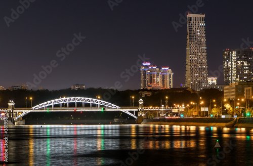 night city with skyscrapers and a bridge over the river with lights reflected in the water. megapolis Moscow