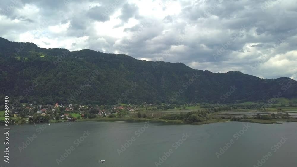 Aerial view on the upper ends of Ossiacher Lake in Carinthia, Austria with its moor and marshlands on a summer day with great cloudscape.