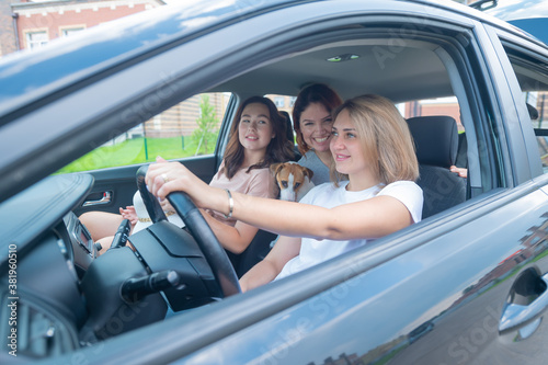 Three friends are traveling in a car with a dog © Михаил Решетников