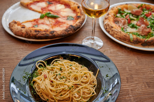 Spaghetti carbonara, pizza, glass of white wine