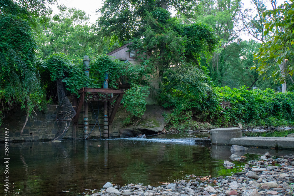 Obraz premium A Small Abandoned Dam in a Creek in Elkins Park, Pennsylvania