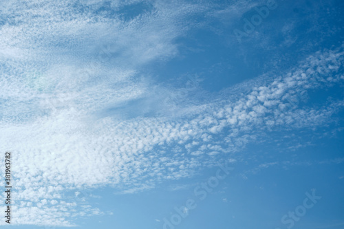 Altocumulus and Cirrocumulus clouds at different levels in a dark turquoise blue sky over England.