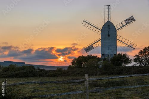 Sun setting behind Ashcombe Windmill from Kingston Ridge south downs near Lewes east Sussex south east England photo