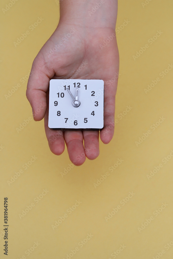 Hand with a clock. Five minutes to twelve. Hand with a clock. Five minutes to twelve.